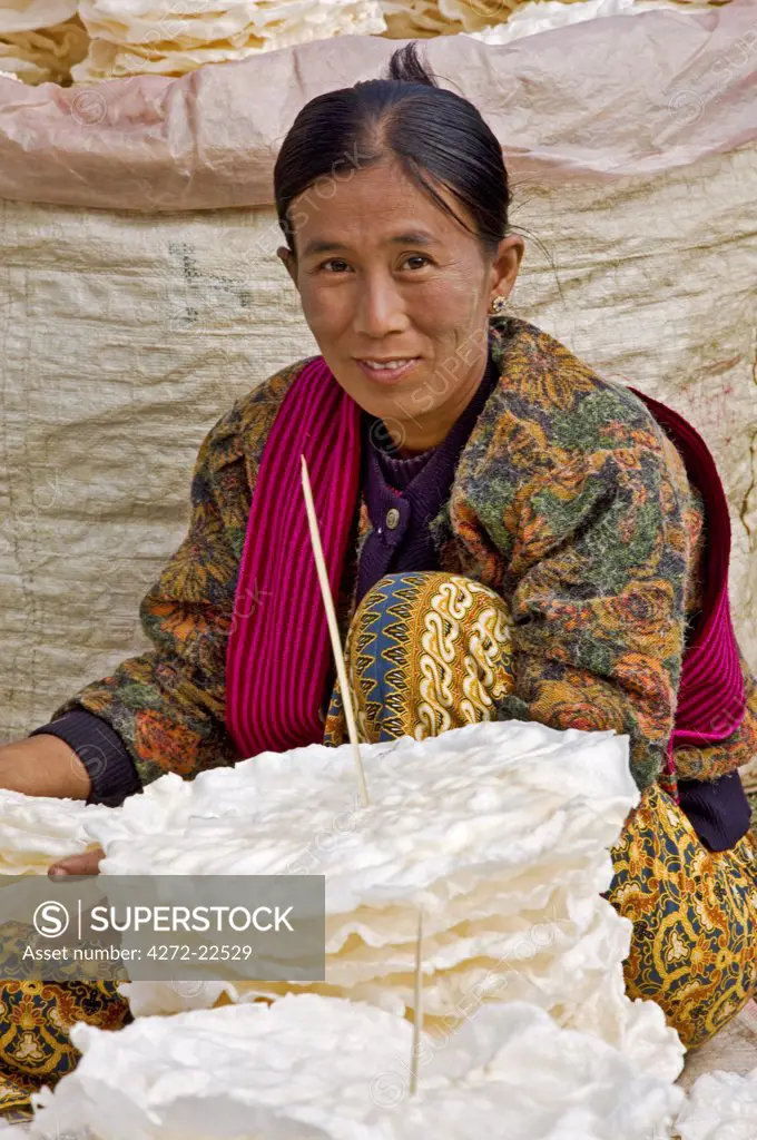 Myanmar, Burma, Lake Inle. A woman selling wafer-thin rice crackers at the popular Phaung Daw Oo market where all kinds of farm produce are sold.