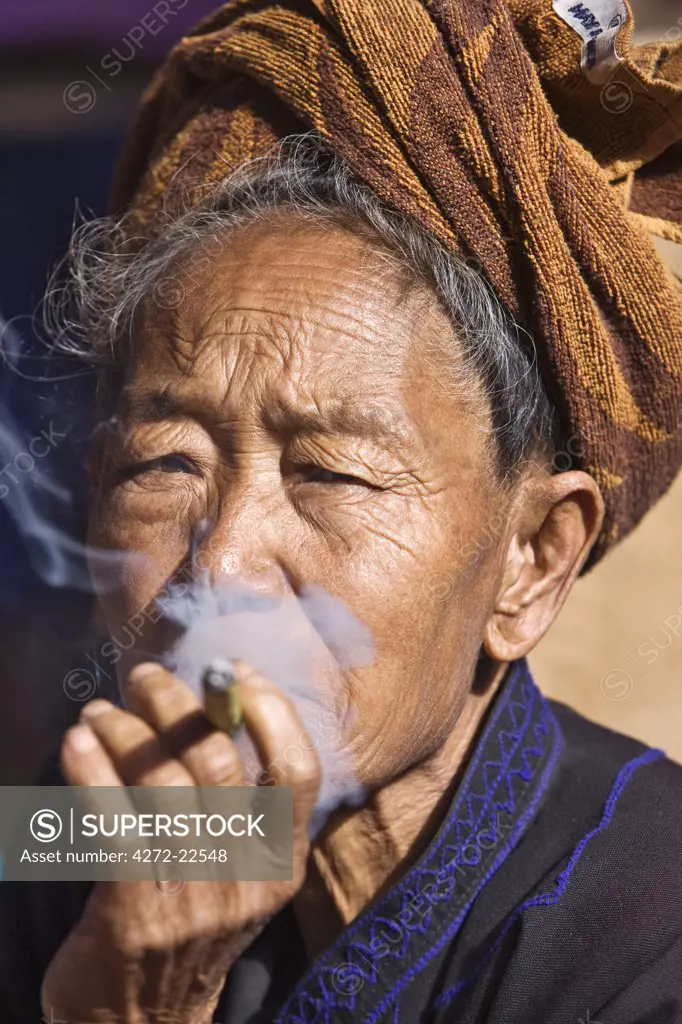 Myanmar, Burma, Lake Inle. An old Pa-O woman smokes a cheroot.