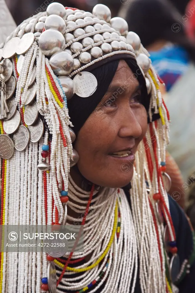 Myanmar, Burma, Kengtung. An Akha woman wearing a traditional headdress of silver and beads.