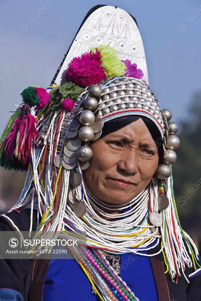 Myanmar, Burma, Kengtung. A Mong la Akha woman wearing a traditional headdress of silver and beads.