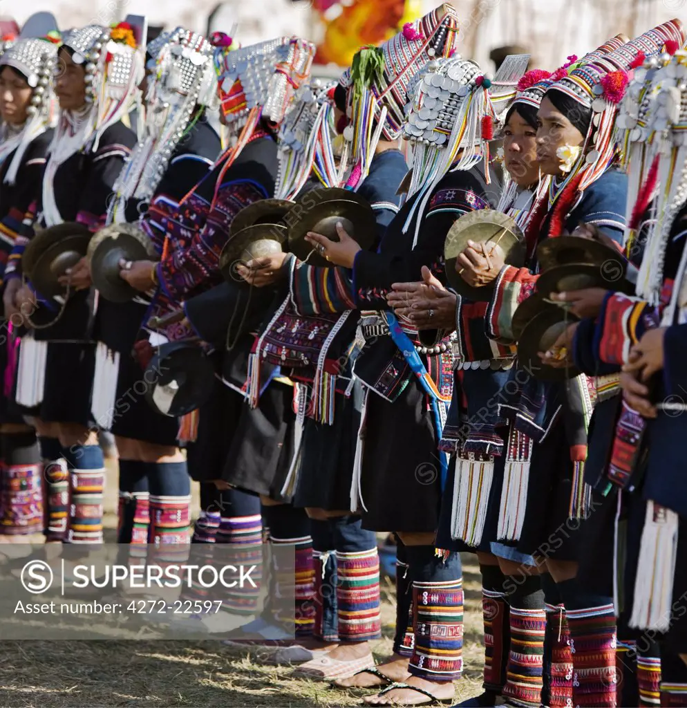 Myanmar, Burma, Kengtung. A group of Akha women wearing traditional costumes and playing cymbals during an Akha festival.