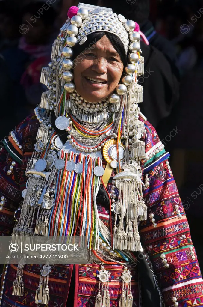 Myanmar, Burma, Kengtung. An Akha woman wearing traditional costume with a silver headdress and necklace embellished with glass beads.