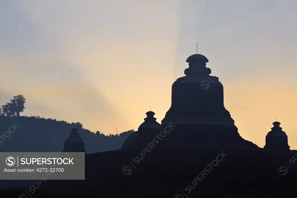 Myanmar, Burma, Mrauk U. Silhouettes of the ancient Buddhist temples of Mrauk U at sunrise.