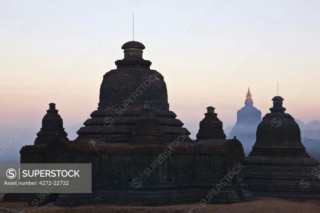 Myanmar, Burma, Mrauk U. Early morning mist swirls around the historic bell-shaped temples of Mrauk U which were built in the Rakhine style between the 15th and 17th centuries.