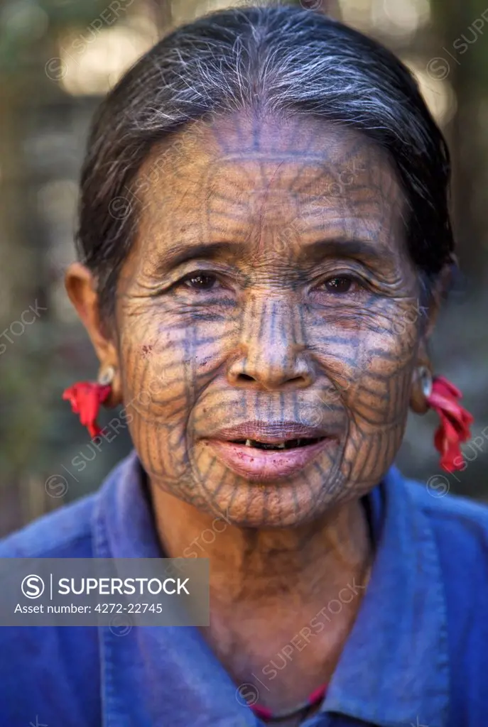 Myanmar, Chin State, Kyi Chaung Village. A Chin woman with tattooed face and mouth stained red due to her habit of chewing beetle nut. Girls used to be tattooed at the age of 14 or 15 years.