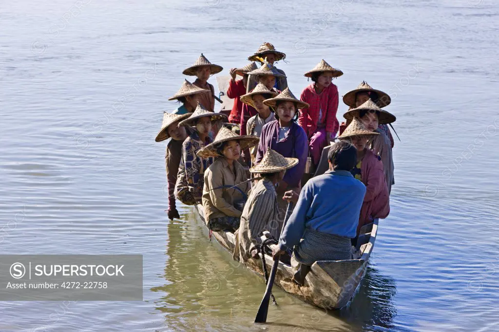 Myanmar, Burma, Rakhine State, Gyi Dawma. In the early morning, the women of Gyi Dawma village cross the Kaladan River by boat to tend their fields on the far side.