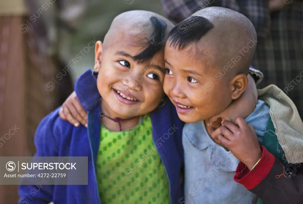 Myanmar, Burma, Rakhine State,Gyi Dawma village. Two young friends at Gyi Dawma village. The small tufts of hair on their shaven heads are believed to protect them.
