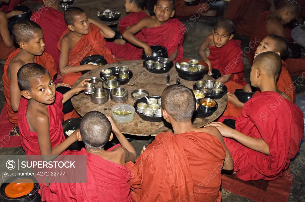 Myanmar, Burma, Rakhine State, Sittwe. Young novice monks eat their main meal at Pathain Monastery where 210 monks live. All their food is donated daily by the community.
