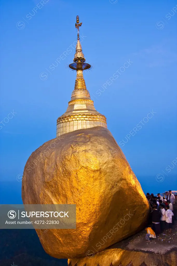 Myanmar, Burma, Golden Rock, Kyaiktiyo. The Golden Rock boulder balanced precariously on the edge of Mount Kyaiktiyo.