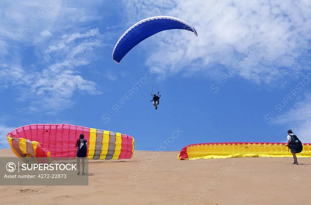 Paragliding over the dunes of the Namib Desert where they meet the onshore coastal winds