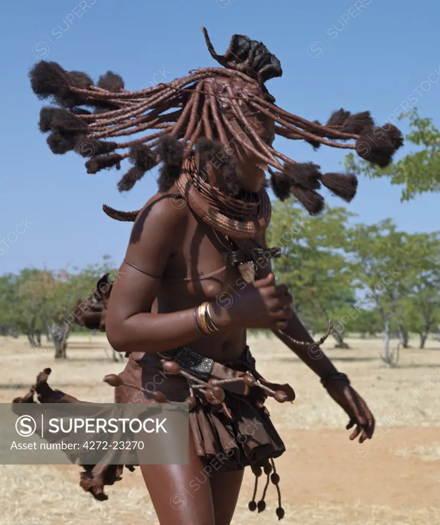 Himba women perform the otjiunda dance, stamping their feet, clapping and chanting while one of them gyrates in the centre of the circle. The Himba are Herero speaking Bantu nomads who live in the harsh, dry but starkly beautiful landscape of remote northwest Namibia.