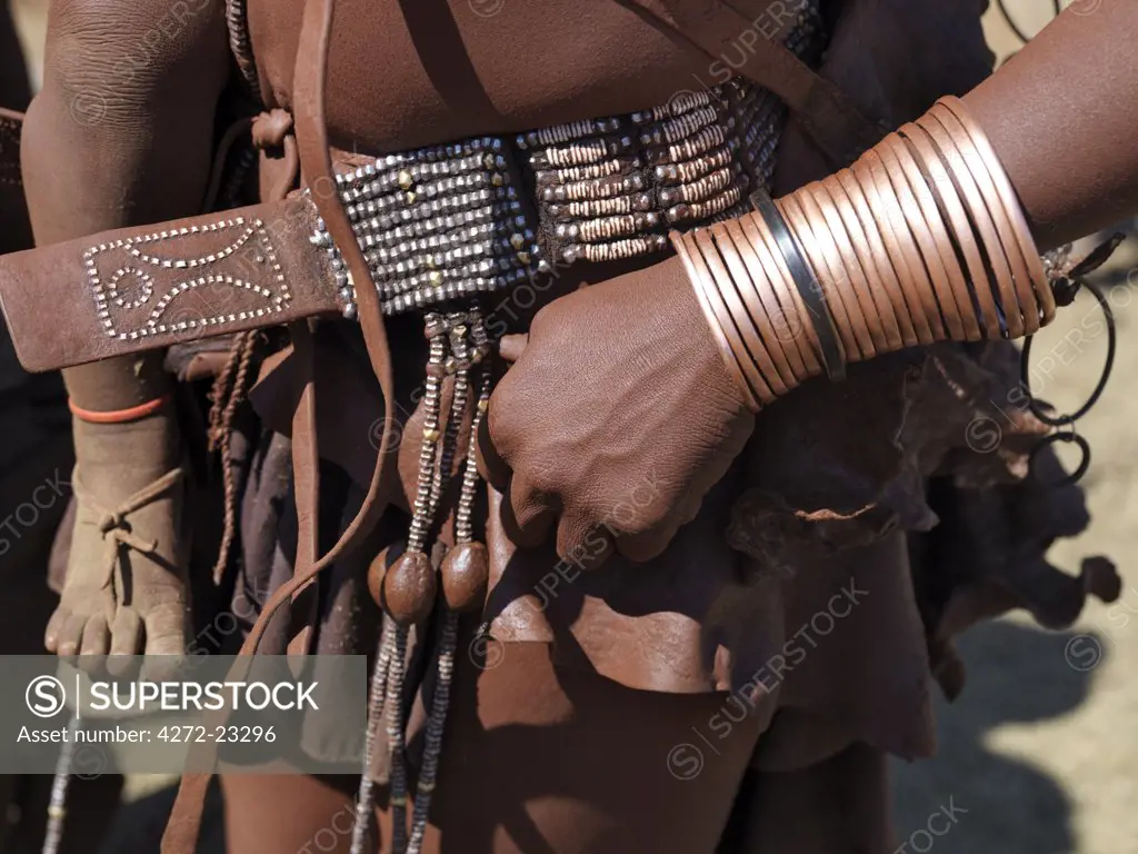 Himba ornaments worn by a woman. Himba women smear their bodies with a mixture of red ochre, butterfat and herbs. They still dress traditionally, wearing leather garments and a variety of ornaments made of leather with wood, ostrich shell and metal beads.  The Himba are Herero-speaking Bantu nomads who live in the harsh, dry but starkly beautiful landscape of remote northwest Namibia.
