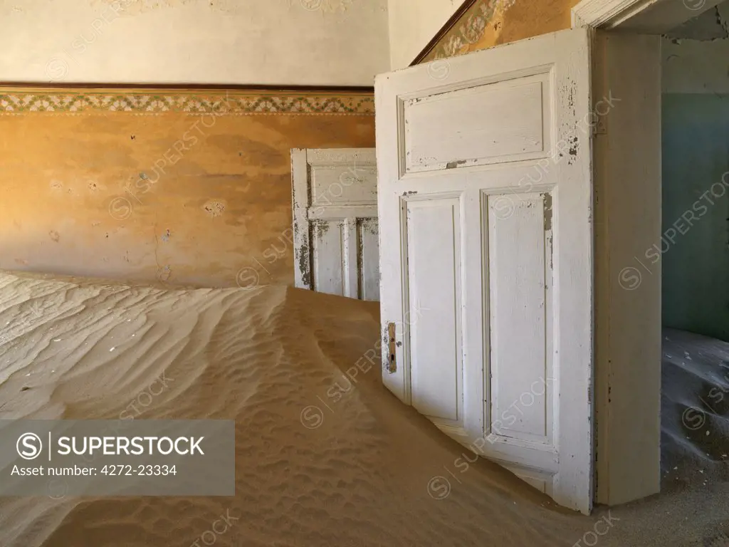 A scene in the deserted diamond-mining town of Kolmanskop, which was abandoned more than fifty years ago.  The place is now a ghost town where sand from the surrounding desert has encroached into all the old buildings of this once prosperous place.