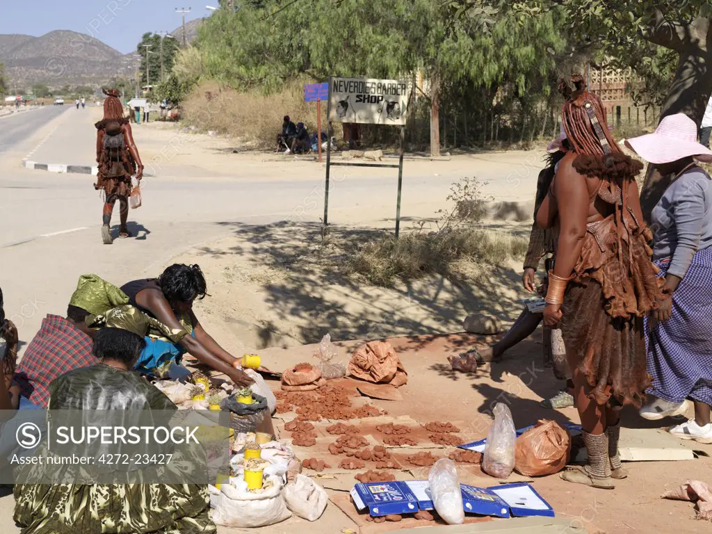 Street vendors selling red ochre at Opuwo, an important administrative centre of the Himba.  The Himba are Herero speaking Bantu nomads who live in the harsh, dry but starkly beautiful landscape of remote northwest Namibia. Himba women dress traditionally.