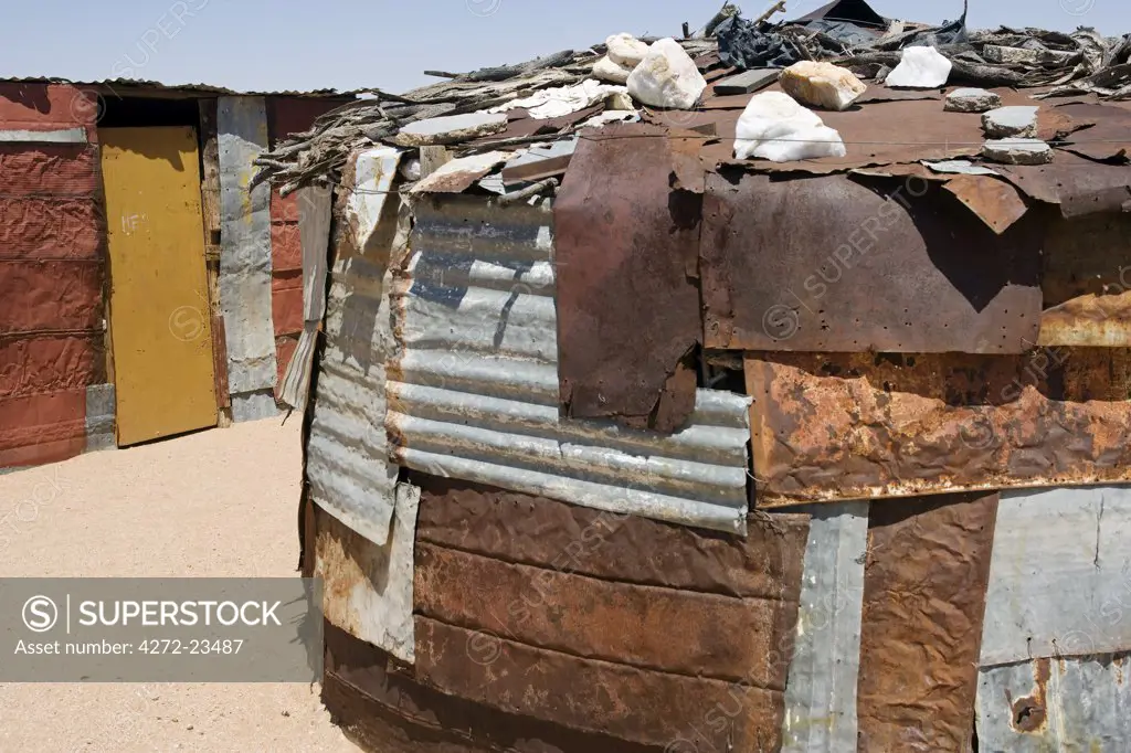 Namibia, Namib Desert, Spitzkoppe. Huts made out of cast off corregated iron sheets in a Damara farming community on the savannah near Spitzkoppe Mountain.