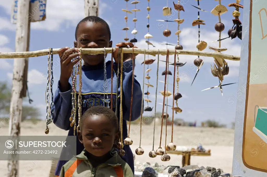 Namibia, Namib Desert, Spitzkoppe Mountain. A community managed nature reserve, local Damara children sell tourist gifts at its entrance.