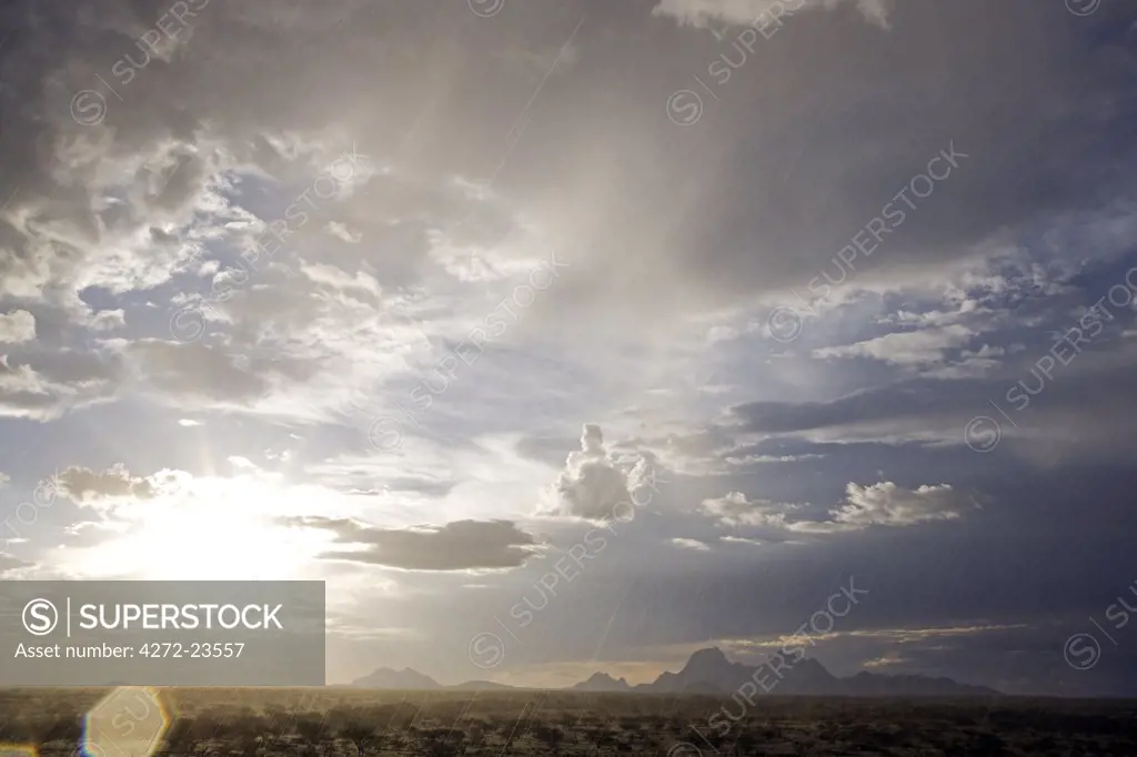 Namibia, Damaraland. Incredible light during stormy weather over Spitzkopje Mountain the 'Matterhorn of Africa' at sunset with cloud build up and massive skies.