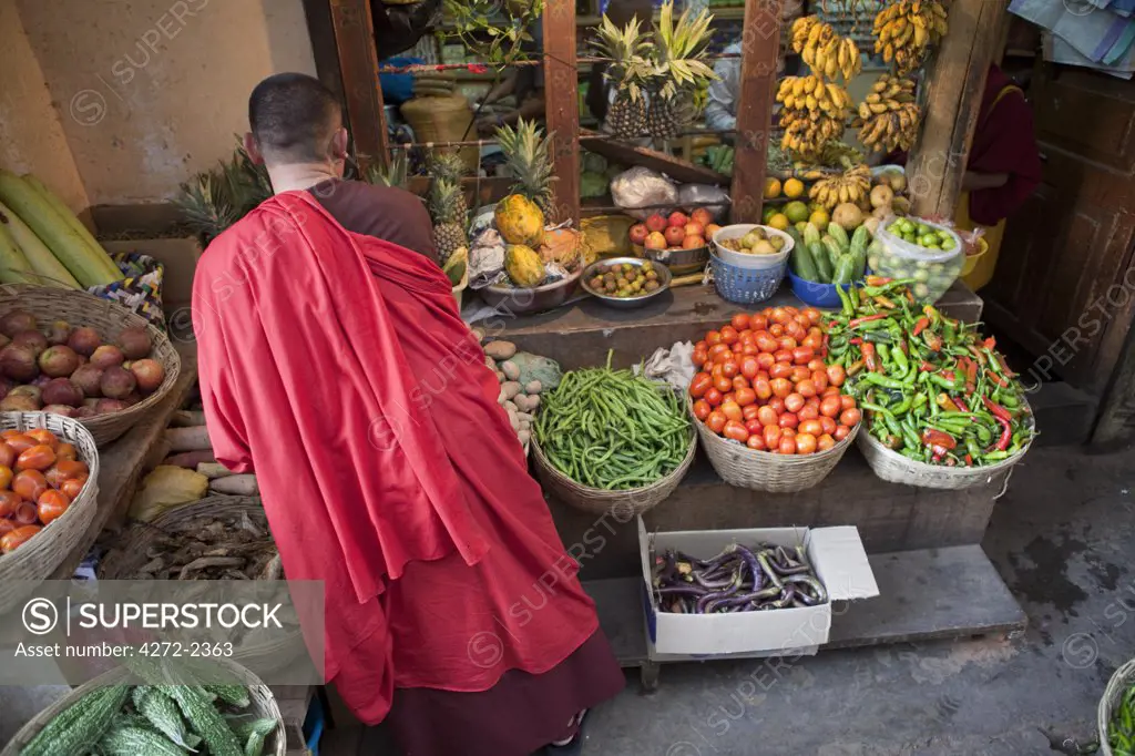 A buddist monk shopping for produce in Thimphu Bhutan