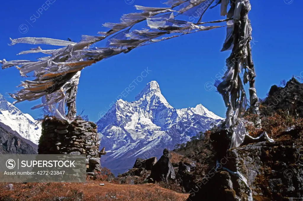 Amma Dablam (west face) framed by prayer flags. Ama Dablam is on of the most distinctive mountains lining the Khumbu valley. At 6856m or 22,494ft, it is by no means the highest mountain in the area, but it is one of the most striking in appearance. First climbed in 1961 by Gill, Bishop, Ward and Romanes.