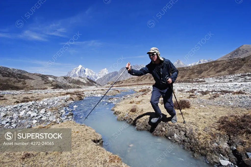 Asia, Nepal, Himalayas, Sagarmatha National Park, Solu Khumbu Everest Region, Unesco World Heritage, Chukhung Valley, trekker at river crossing (MR)