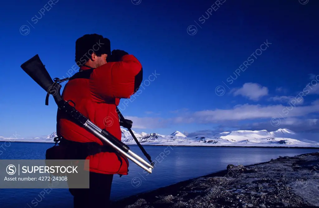 Armed guide checking for polar bears prior to land excursion.