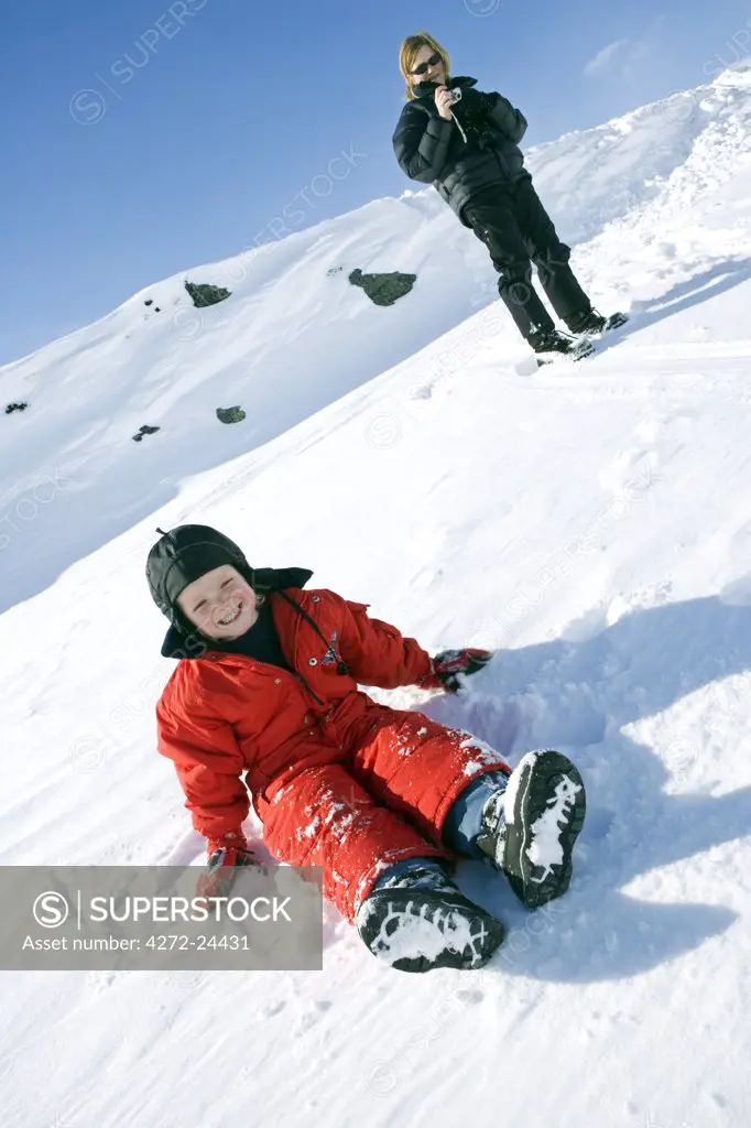Norway, Tromso, Lyngen Alps. Mother and young daughter play in the snow at the top of the Lyngen Alps. (MR)