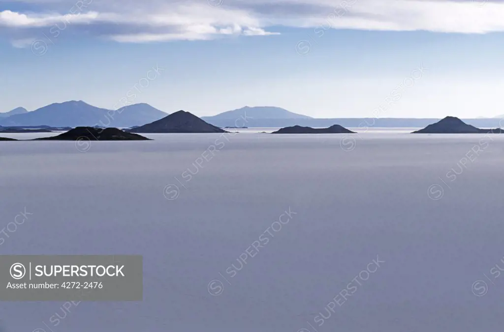 View across the great white expanse that is the Salar de Uyuni,  the largest salt flat in the world, towards the distant Andean peaks.