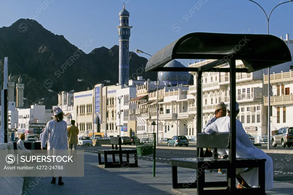 Omanis walk and sit alongside Muttrah's busy Corniche