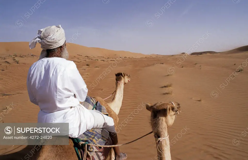 A Bedu rides his camel in the desert