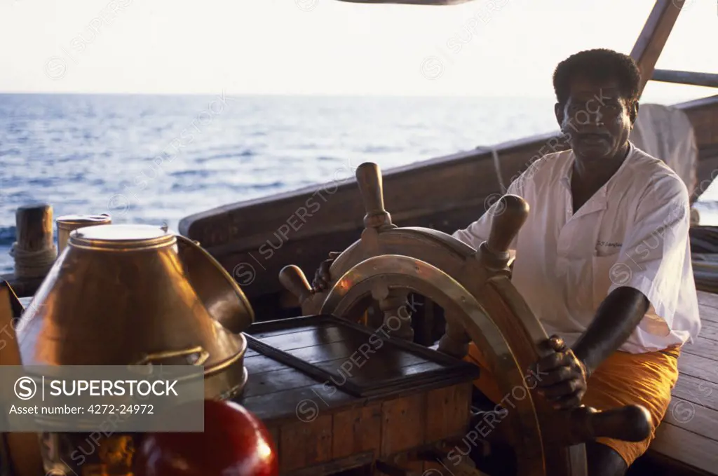 Crew member takes the wheel on the bridge of S/Y Sanjeeda.  Sanjeeda is a traditional kotiya dhow of the type that traded throughout the Indian Ocean.