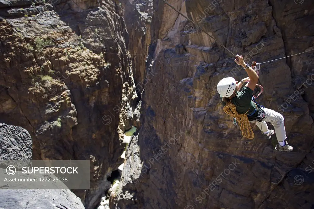 Oman, Western Hajar Mountains, Snake Canyon.  A newly installed Via Ferrata ( Iron Way ) enables climbers and adventure seekers to cross otherwise inaccessible canyons and explore its mountains only a few hours from Muscat.  British climber Justin Halls shows the way.