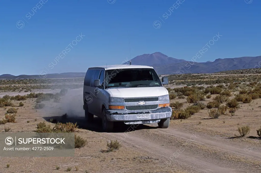 A tourist vehicle drives along a dirt road through the altiplano en route to Pisiga Bolivar  border post with Chile