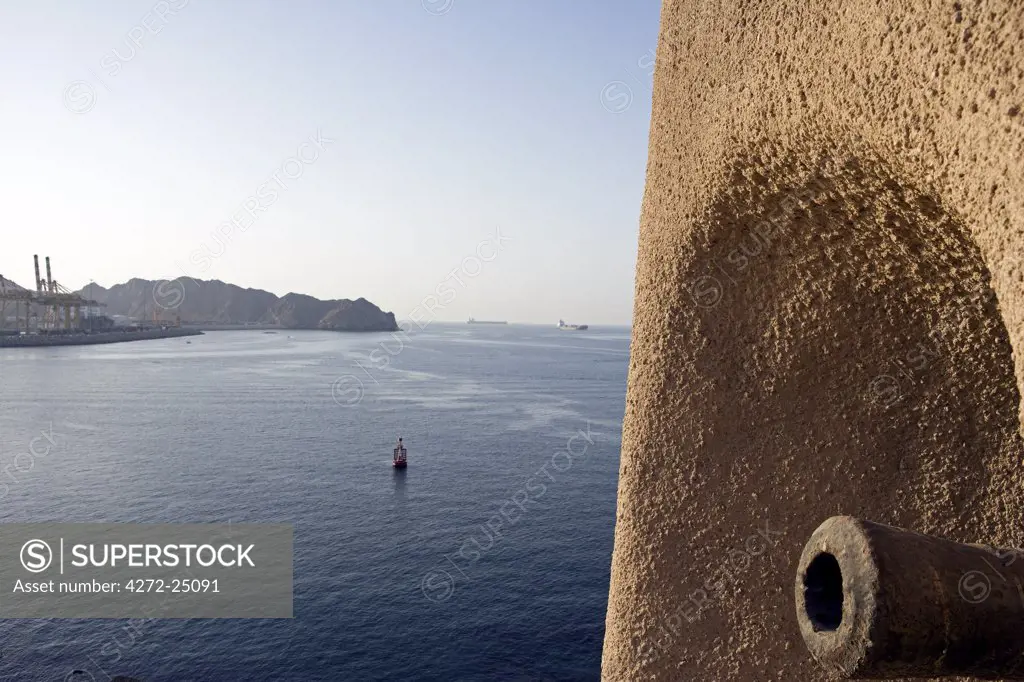 Oman, Muscat. A historic cannon on a fort overlooking the entrance to the port of Muscat.