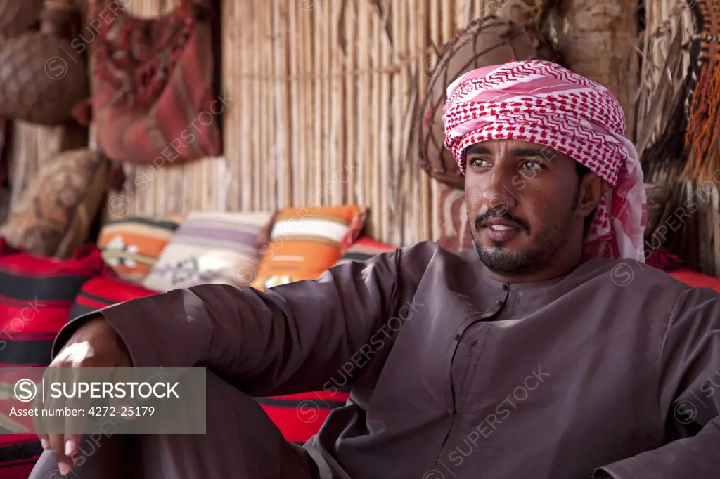 Oman, Wahiba Sands. A guide relaxes at the Nomadic Desert Camp.