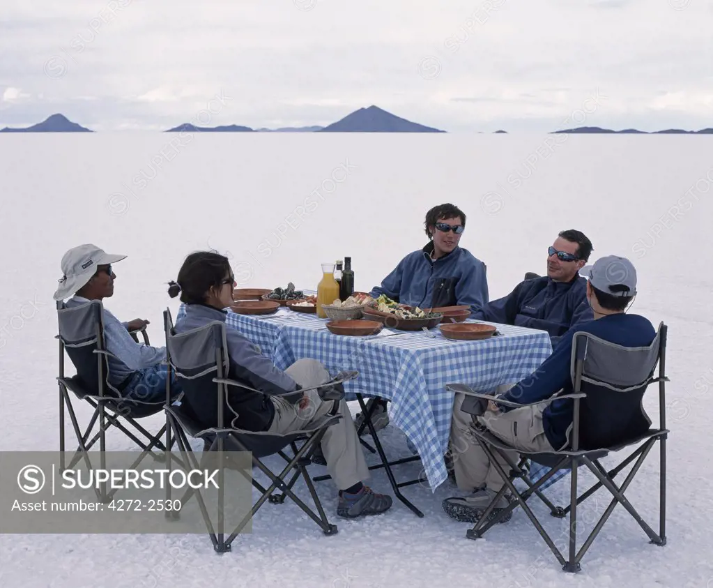 Guests on the Explora Traversia of southern bolivia enjoy lunch set out on the salt crust  of the Salar de Uyuni, the largest salt flat in the world at over 12,000  square kilometres.