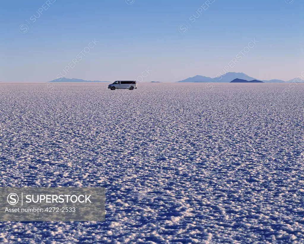 A tourist vehicle crosses the endless salt crust  of the Salar de Uyuni, the largest salt flat in the world at over 12,000  square kilometres.
