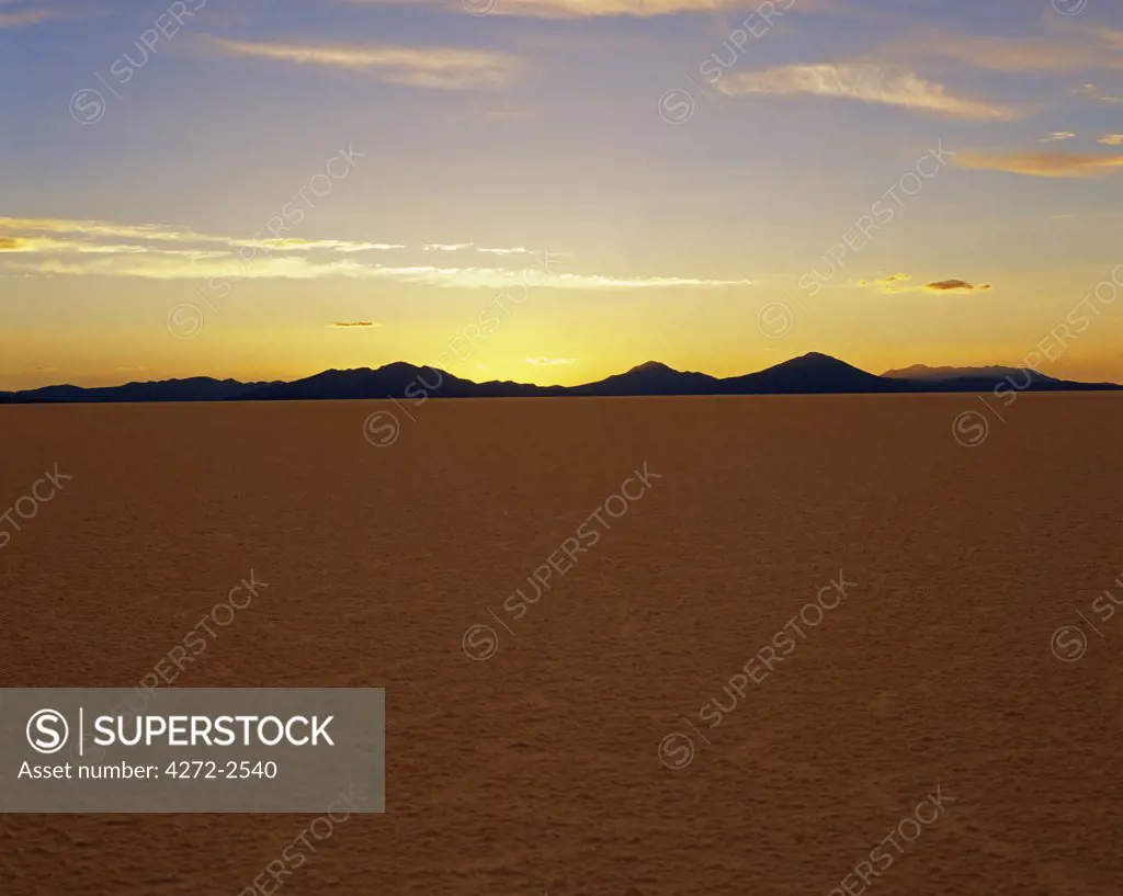 The sun sets behind the Andes, seen from the endless salt crust of the Salar de Uyuni, the largest salt flat in the world at over 12,000  square kilometres.