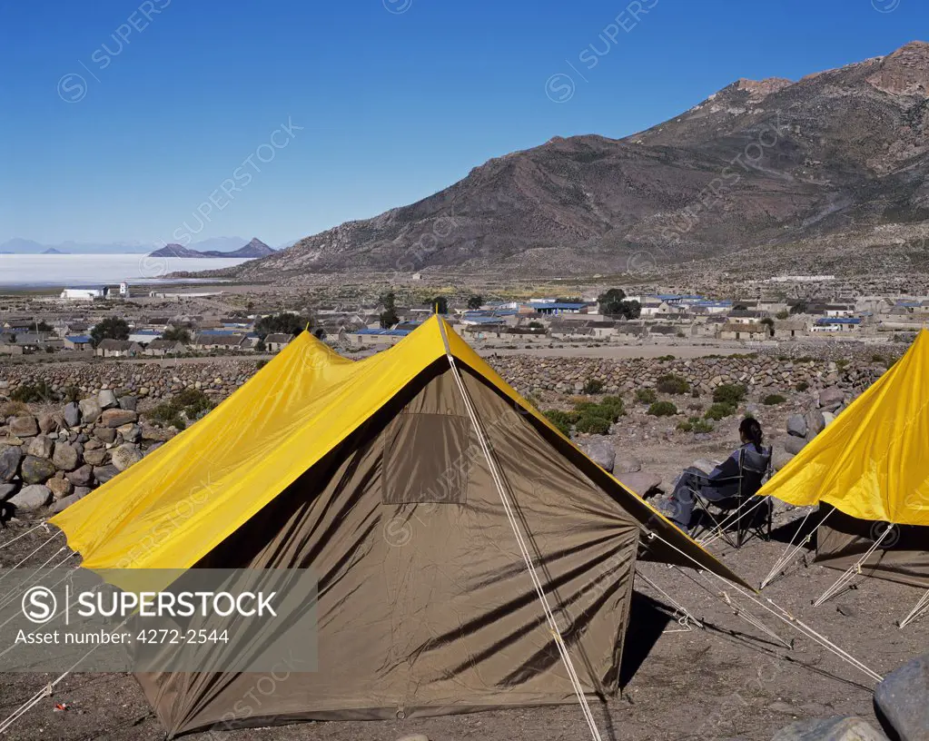 A guest sits by her tent at Explora's camp at the village of Tahua on the northern shore of the Salar de Uyuni, the largest salt flat in the world at over 12,000  square kilometres.