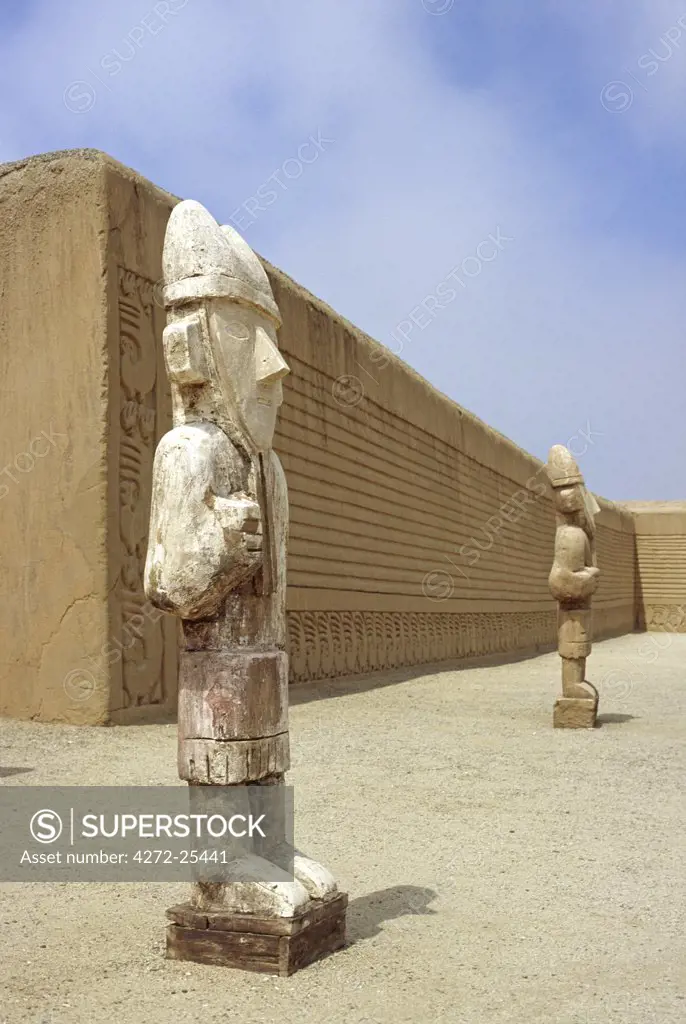 Wooden reproductions of Chimu statues stand in the Ceremonial Courtyard of the Tschudi Complex. The Complex is part of the ancient adobe site of Chan Chan, near Trujillo in Peru.