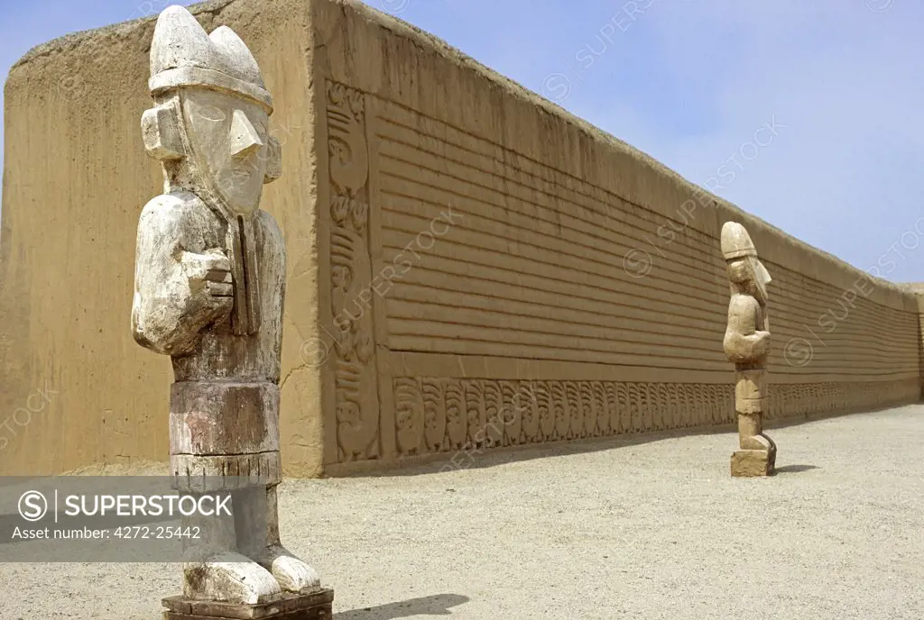 Wooden reproductions of Chimu statues stand in the Ceremonial Courtyard of the Tschudi Complex. The Complex is part of the ancient adobe site of Chan Chan, near Trujillo in Peru.