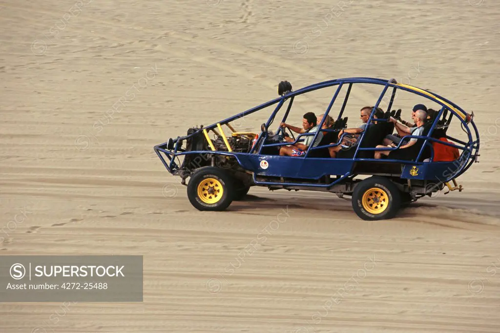 A dune buggy speeds tourists acoss through the sand dunes near Huacachina, in southern Peru.