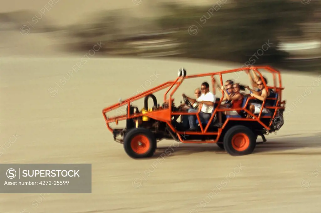 A dune buggy speeds tourists acoss through the sand dunes near Huacachina, in southern Peru.