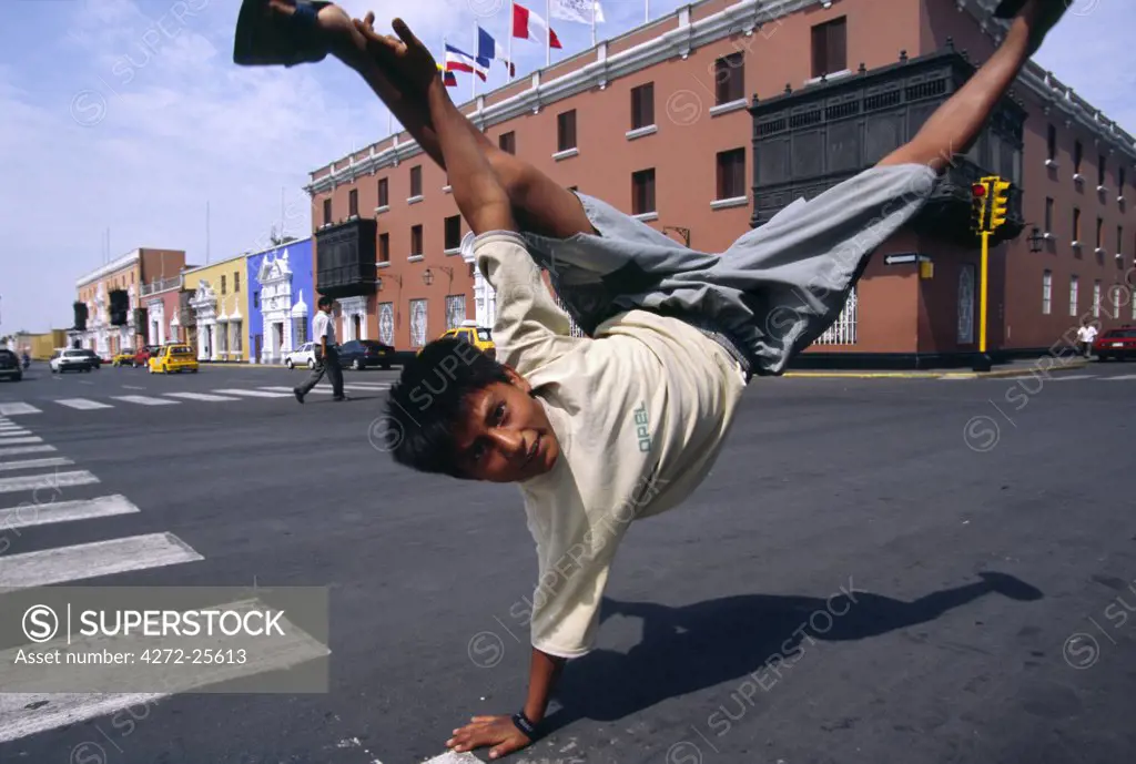 A youth performs an armstand on the streets of Trujillo in northern Peru. Kids performing acrobatics for change from passing motorists are a common scene in Peru's third largest city.