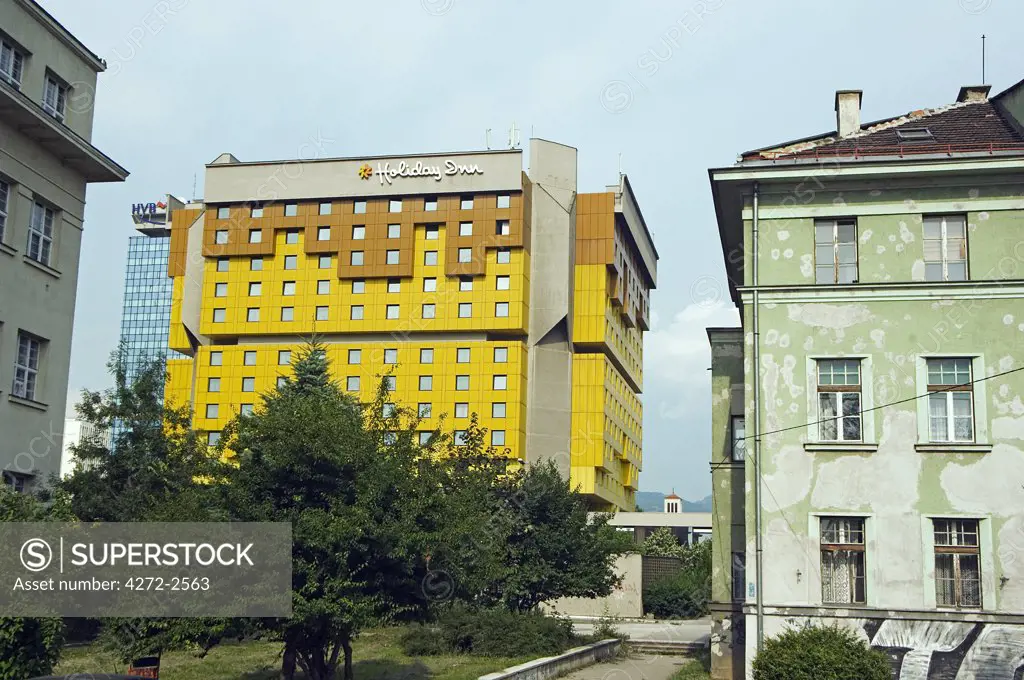 Sarajevo Holiday Inn on 'Sniper Alley' newly repainted next to heavily war damaged houses