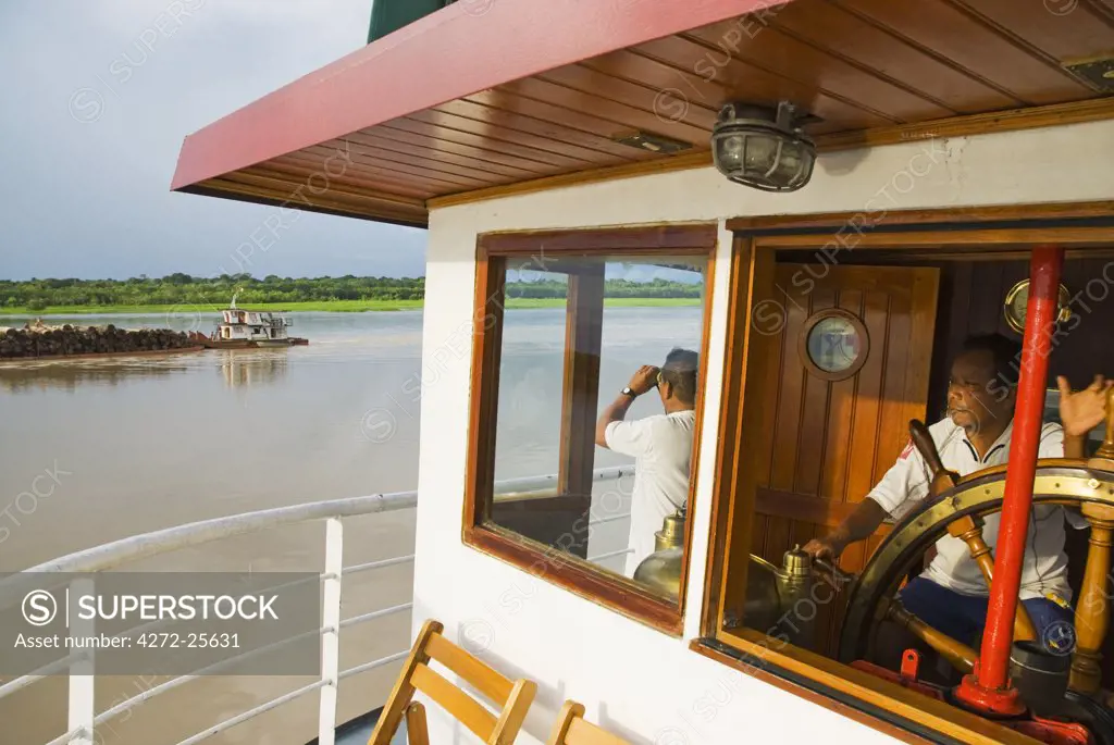 Peru, Amazon, Amazon River. Crew steering the Ayapua Riverboat up the Amazon River.