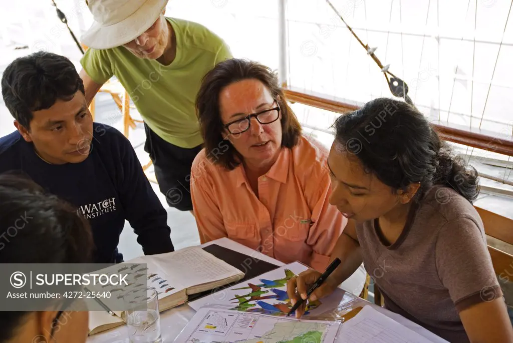 Peru, Amazon, Amazon River. Peruvian scientists explaining survey and observation techniques to Earthwatch volunteers on board the Ayapua riverboat, Lago Preto. (MR).