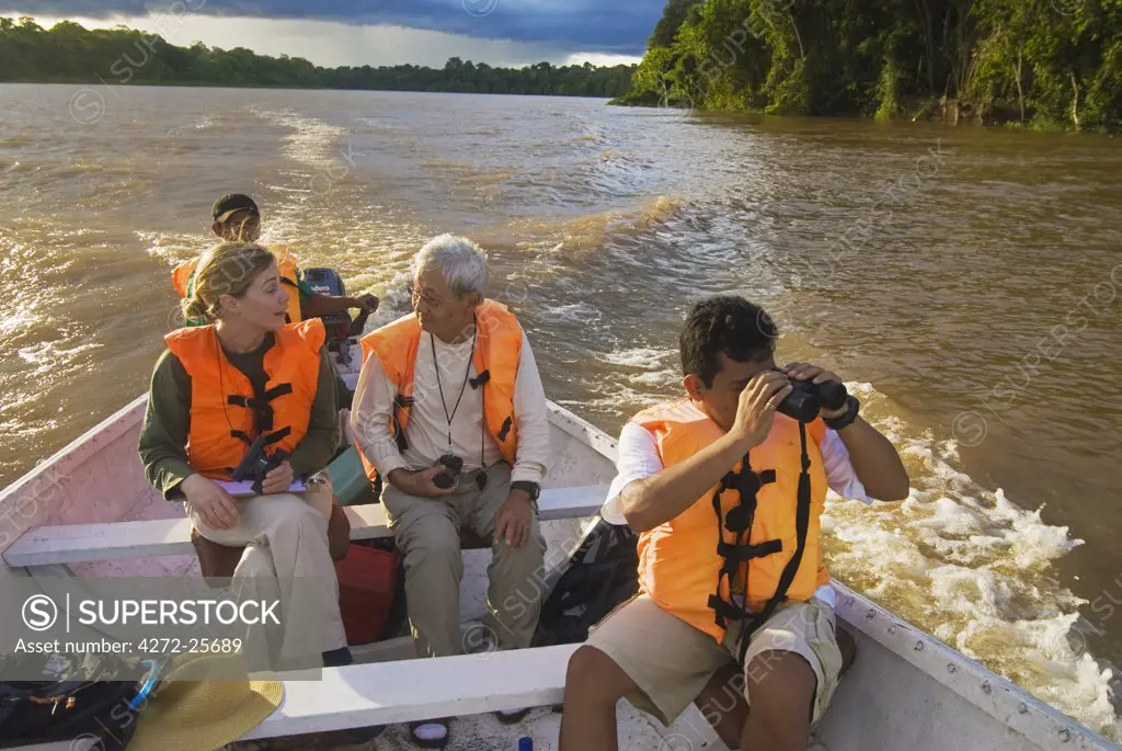 Peru, Amazon, Amazon River. Earthwatch volunteers and scientists travelling on the Yavari River to a site for observing Macaw population, Amazon, Peru. (MR).