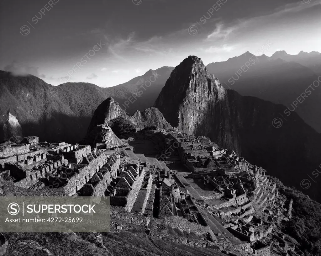 Peru, Urubamba Valley.  The first rays of sunlight catch the ancient Inca citadel of Machu Picchu at dawn.