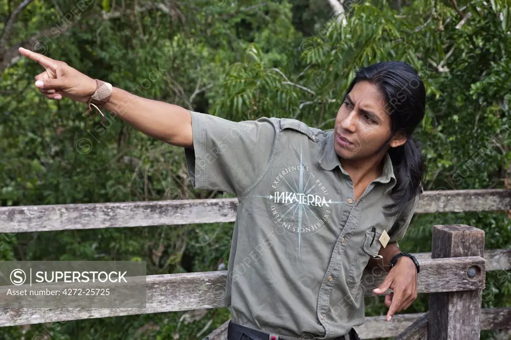 Peru. Jesus, an experienced local guide at Inkaterra Rerserve Amazonica, pointing out birds on the treetop-canopy walk.