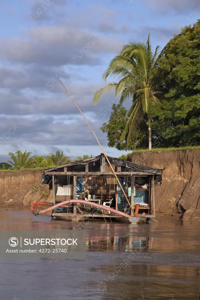 Peru. A floating dredge on the Madre de Dios River, which is used for extracting alluvial gold from the river bed.